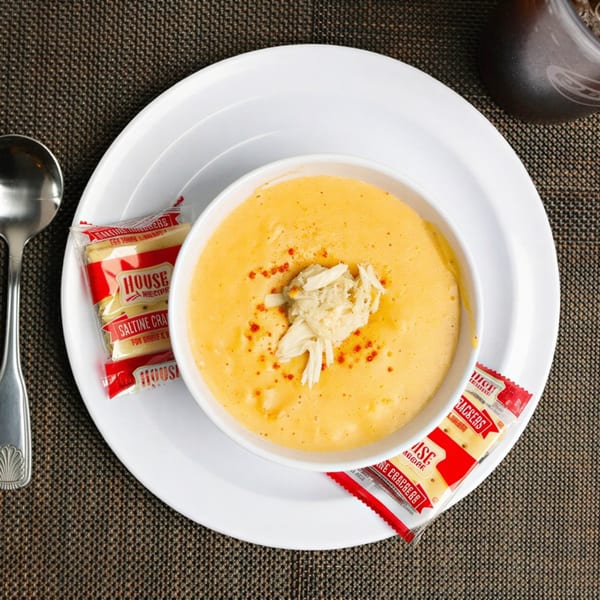 Creamy yellow crab bisque topped with crab meat and red spice, served with saltine crackers.